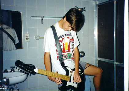 Guga tocando guitarra no banheiro.